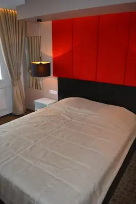 a bedroom with a large bed with a red headboard at Mokomasis svetingumo centras in Utena