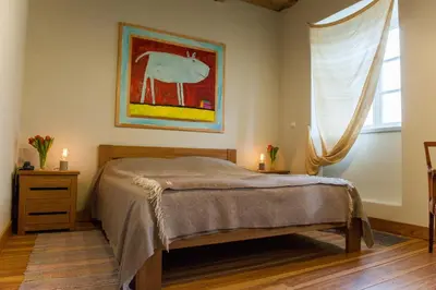 a bedroom with a bed and a painting on the wall at Paliesiaus Dvaras in Mielagėnai