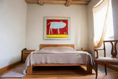 a bedroom with a bed and a painting on the wall at Paliesiaus Dvaras in Mielagėnai