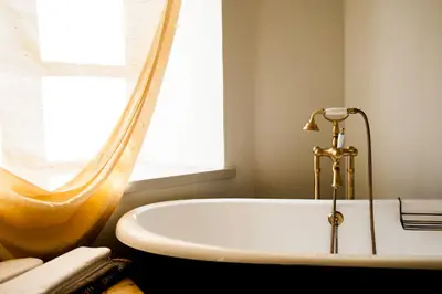 a white bath tub in a bathroom with a window at Paliesiaus Dvaras in Mielagėnai