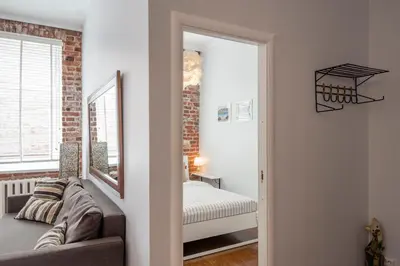a living room with a couch and a mirror at Maironis Apartment in Kaunas