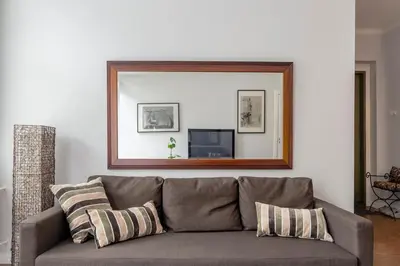 a mirror above a couch in a living room at Maironis Apartment in Kaunas