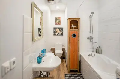a bathroom with a sink and a tub and a toilet at Maironis Apartment in Kaunas