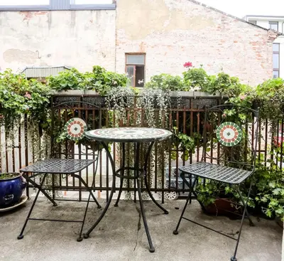 a table and chairs in front of a fence at Maironis Apartment in Kaunas