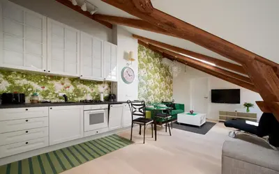 a kitchen with white cabinets and a living room at Town Hall Apartments FREE Parking in Vilnius