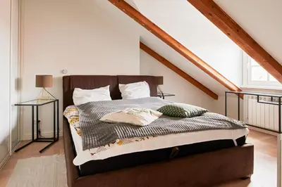 a bedroom with a bed in a attic at Town Hall Apartments FREE Parking in Vilnius
