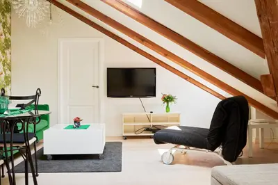 a living room with wooden ceilings and a tv at Town Hall Apartments FREE Parking in Vilnius