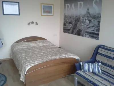 a small bedroom with a bed and a chair at 1 kambario butas in Panevėžys