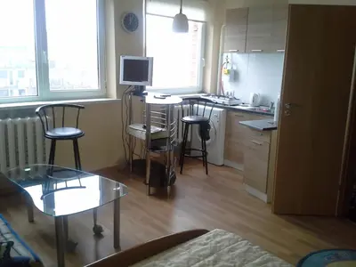 a small kitchen with a table and chairs and a counter at 1 kambario butas in Panevėžys