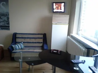 a room with a chair and a table and a window at 1 kambario butas in Panevėžys