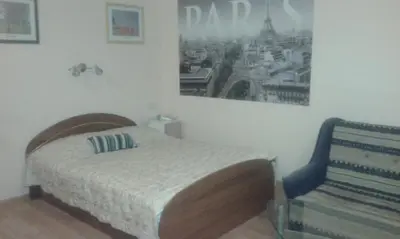 a bedroom with a bed and a chair in it at 1 kambario butas in Panevėžys