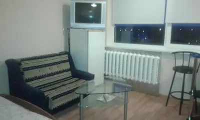 a living room with a couch and a glass table at 1 kambario butas in Panevėžys