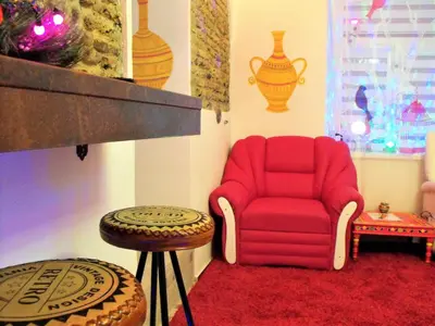 a living room with a red chair and a table at President Apartments in Vilnius
