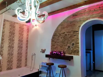 a room with a brick wall and a chandelier at President Apartments in Vilnius