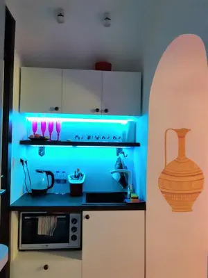 a kitchen with a blue light on a stove at President Apartments in Vilnius