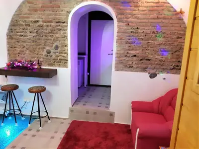 a living room with a red couch and a brick wall at President Apartments in Vilnius