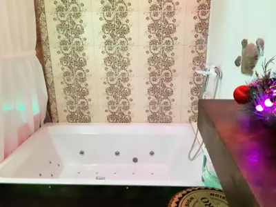 a white bath tub in a bathroom with a counter at President Apartments in Vilnius