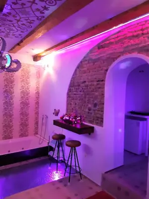 a room with a tub and two stools and a table at President Apartments in Vilnius