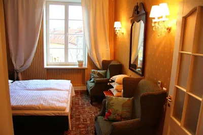 a hotel room with a bed and chairs and a window at German18-3A Luxury Vilnius apartment in Vilnius