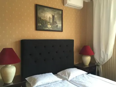 a bedroom with a bed with two lamps and a painting at German18-3A Luxury Vilnius apartment in Vilnius