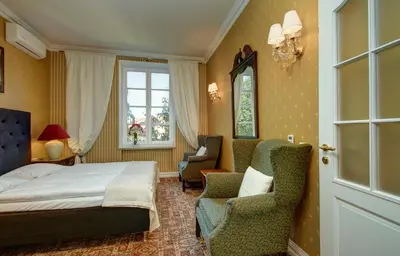 a bedroom with a bed and chairs and a window at German18-3B Luxury Vilnius apartment in Vilnius