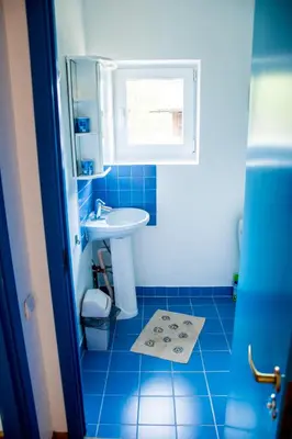 a blue bathroom with a sink and a mirror at Ramybes Uostas in Švedriškė