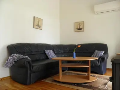 a living room with a black couch and a table at Ramybes Uostas in Švedriškė