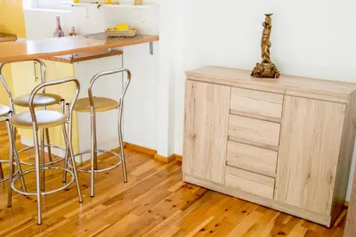 a kitchen with a wooden counter and stools at Ramybes Uostas in Švedriškė