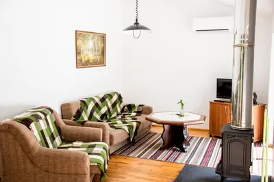 a living room with two couches and a table at Ramybes Uostas in Švedriškė