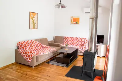 a living room with a couch and a wood stove at Ramybes Uostas in Švedriškė