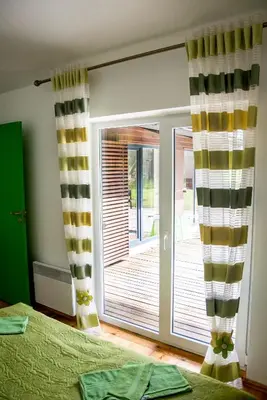 a bedroom with a sliding glass door to a deck at Ramybes Uostas in Švedriškė
