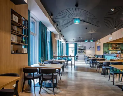 a restaurant with tables and chairs and windows at UPA Medical SPA in Druskininkai
