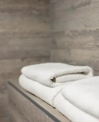 a stack of white towels sitting on a counter at UPA Medical SPA in Druskininkai