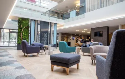 a lobby with chairs and a table and people at UPA Medical SPA in Druskininkai
