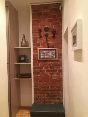 a brick wall in a hallway with a green bench at Kranto Luxe Stay in Panevėžys