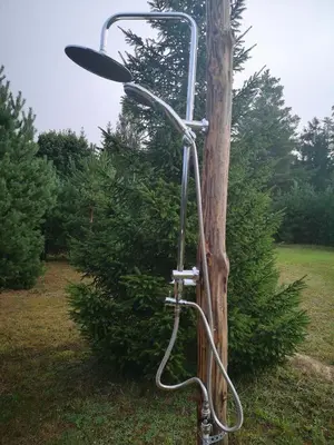 a shower hooked up to a telephone pole at Kryzbarkas in Degučiai