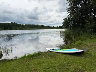 a canoe sitting on the shore of a lake at Dabintos slėnis in Sumiliszki