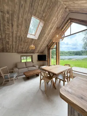 a living room with a table and a couch at Dabintos slėnis in Sumiliszki
