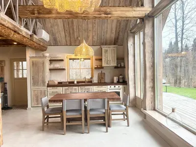 a kitchen with a wooden table and some chairs at Dabintos slėnis in Sumiliszki