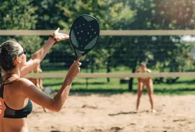 a woman swinging a racket at a volleyball game at Dabintos slėnis in Sumiliszki