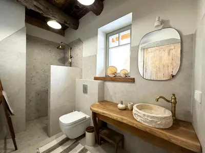 a bathroom with a sink and a toilet and a mirror at Dabintos slėnis in Sumiliszki