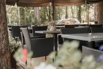 a group of tables and chairs under an umbrella at Pušynė in Birštonas