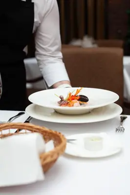 a person sitting at a table with a plate of food at Pušynė in Birštonas