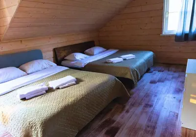 two beds sitting in a room with wooden walls at Sodybos kompleksas - ECO Resort Trakai in Antakalnis