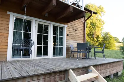 a porch of a house with chairs and a table at Sodybos kompleksas - ECO Resort Trakai in Antakalnis
