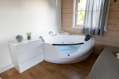 a white bath tub in a room with a window at Sodybos kompleksas - ECO Resort Trakai in Antakalnis