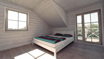 a bed in a white room with two windows at Sodybos kompleksas - ECO Resort Trakai in Antakalnis