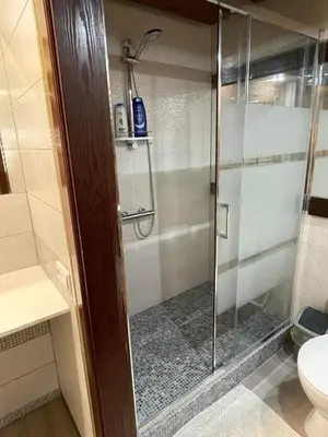 a shower with a glass door in a bathroom at Akmenine Kerpe in Marijampolė