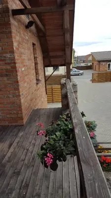 a wooden deck with flowers and plants on it at Akmenine Kerpe in Marijampolė