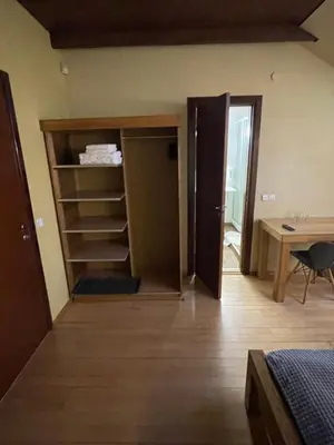 a bedroom with a closet and a desk and a table at Akmenine Kerpe in Marijampolė